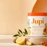 Is Instant Hydration Pregnancy Safe? Ingredients, Benefits and Precautions Jupi Hydration review showing the citrus ginger supplement tub with a yellow hydration drink, lemon, ginger, turmeric, kiwi, and papaya