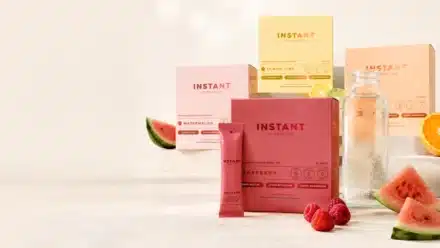 Instant Hydration packets and electrolyte drink mix boxes in multiple flavors beside a clear water bottle